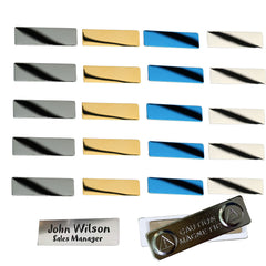 A set of 20 Packs 4 Colors Stainless Steel Blank Name Tags Badges Nameplate for Laser Engraving in various colors (silver, gold, blue, and white) arranged in four rows of five. Below the name tags, there's a metal name badge crafted with precision using laser technology that reads "John Wilson Sales Manager" with a magnetic fastener displaying the warning "CAUTION MAGNETIC." The product is by CrealityFalcon.