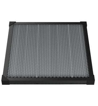 A square-shaped, black-framed Falcon Honeycomb Workbench for Laser Engraver 500mm * 500mm by CrealityFalcon features a honeycomb-patterned gray surface. The corners of the frame are reinforced with black plastic caps for durability, and its textured design effectively traps particles and impurities while ensuring excellent heat dissipation.