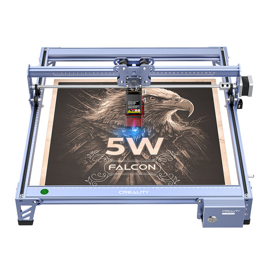 A blue CR-Laser Falcon 5W Laser Engraver from CrealityFalcon, featuring a wood panel with an intricately laser-etched eagle design and the text "5W FALCON" below it. The ultra-fine engraving precision of this device, versatile with over 300 materials, makes it a standout in its category. 1000