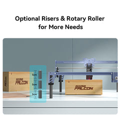 Image of a table with wooden blocks labeled "CrealityFalcon." There is a gray CR-Laser Falcon 5W Laser Engraver on the table. A blue text box highlights optional risers and a rotary roller option for the machine, offering ultra-fine engraving precision in 5 cm increments. Text above reads, “Optional Risers & Rotary Roller for More Needs.”