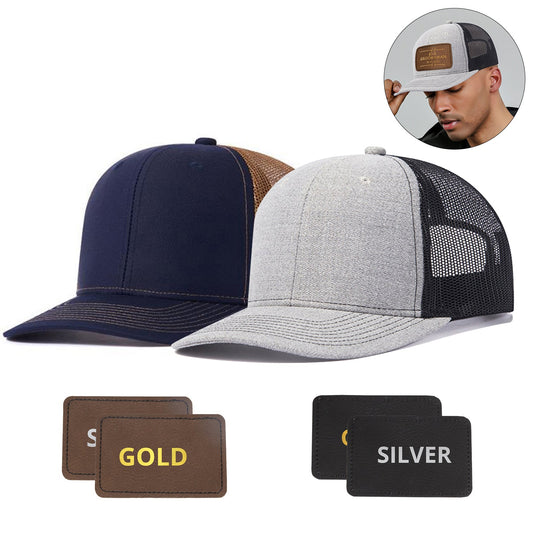 Two CrealityFalcon 2 pcs Adjustable Men Mesh Trucker Hats with 4pcs Self-adhesive Cap Stickers for Laser Engraving are displayed side by side. One hat is navy blue with a brown mesh back, and the other is light grey with a black mesh back. Dimensions of the hats are listed above them, while below, two laser-engraved patches labeled "GOLD" and "SILVER" showcase fine craftsmanship. 1600