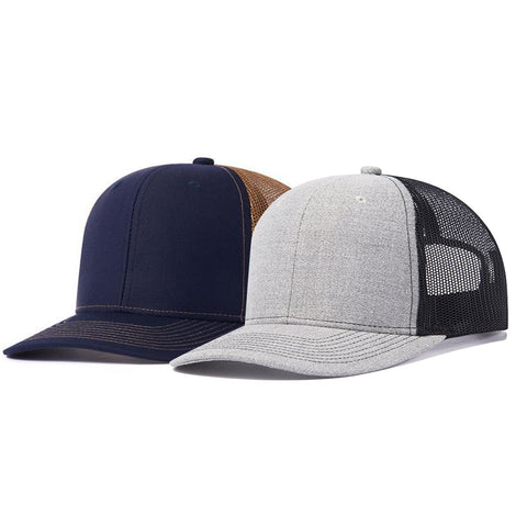 Two snapback trucker hats are displayed side by side. The hat on the left is navy blue with a brown mesh back, while the hat on the right is light grey with a black mesh back. Both have curved brims and are positioned facing forward, perfect for adding personal laser crafts or showcasing your CrealityFalcon 2 pcs Adjustable Men Mesh Trucker Hat with 4pcs Self-adhesive Cap Stickers for Laser Engraving designs.