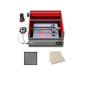 The Creality Falcon Falcon2 Pro 40W and 22W Enclosed Laser Engraver and Cutter, with its open red cover, illustrates Class 1 Safety while engraving a floral pattern on a sheet. Accompanying items include a small black component, a gridded black mat for visual assistance, and three wooden sheets positioned to the right of the machine.