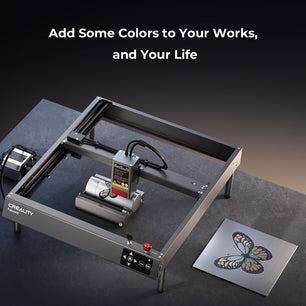 A CrealityFalcon Falcon2 40W Laser Engraver and Cutter is displayed on a dark surface. Next to it lies a metal plate with an engraved, multicolored butterfly design. Above the scene, text reads, 